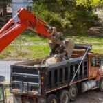 Truck with excavator loading for removal of waste building demolition debris construction